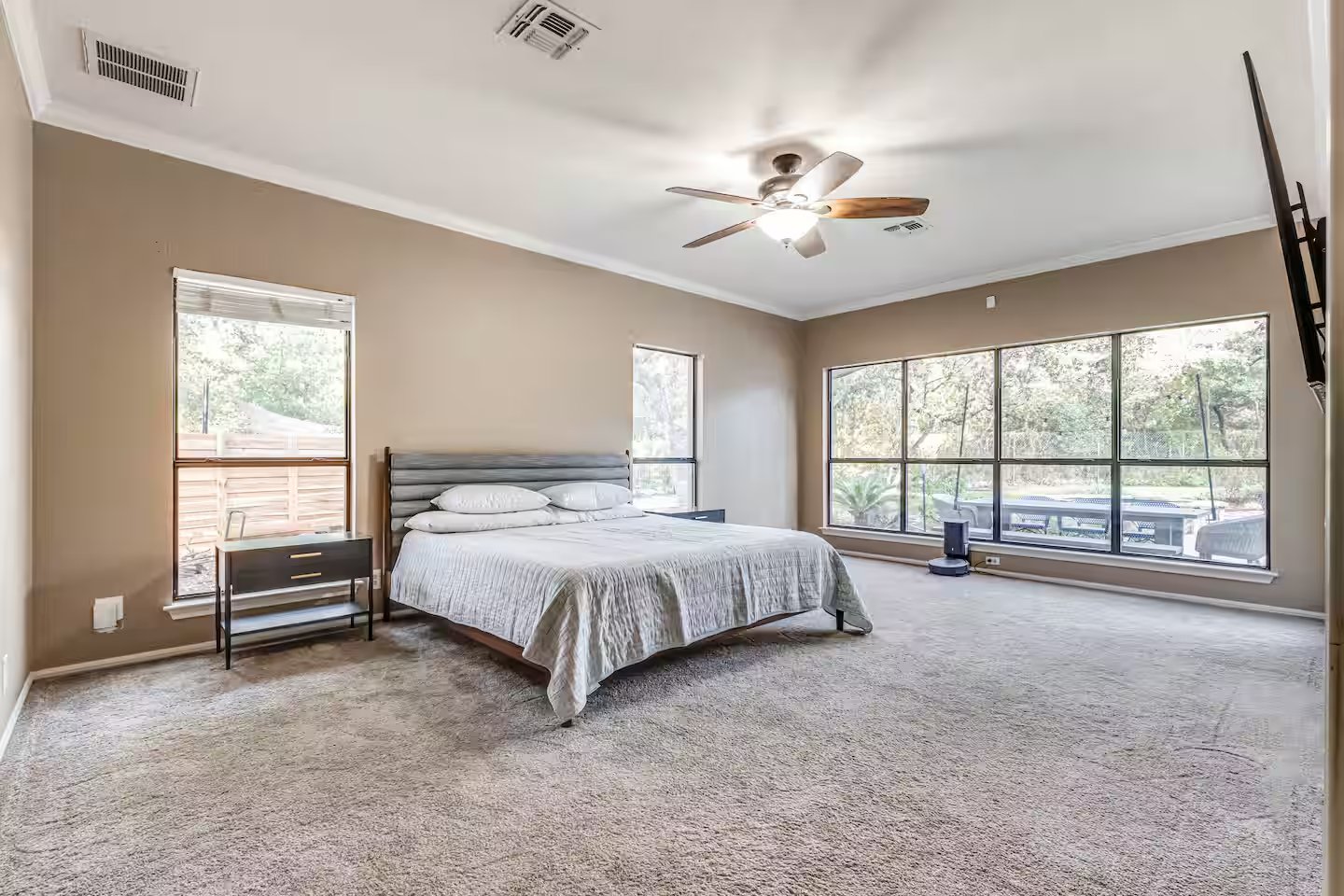 Primary bedroom with king bed and large windows overlooking the yard