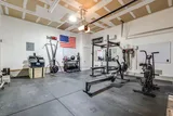Garage gym with squat rack, bench, and cardio equipment