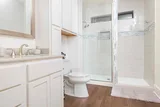 Updated bathroom with walk-in glass shower and white cabinetry